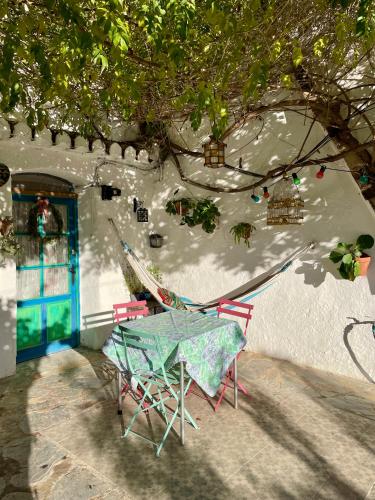 a table and chairs sitting in front of a building at Casa Cueva Muntasal in Monachil