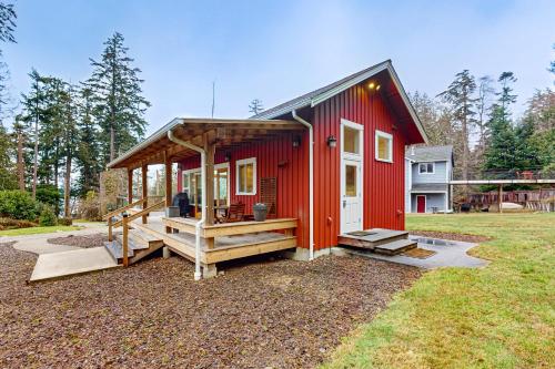 a red tiny house with a porch in a yard at Saratoga Passage Bungalow in Baby Island Heights