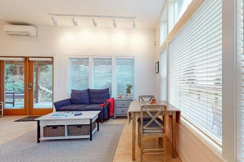 a living room with a blue couch and a table at Saratoga Passage Bungalow in Baby Island Heights