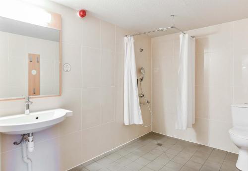 a bathroom with a sink and a toilet and a mirror at B&B HOTEL Toulouse Centre Canal du Midi in Toulouse