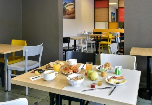 a table with breakfast foods and drinks on it at B&B HOTEL Toulouse Centre Canal du Midi in Toulouse