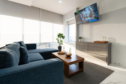 a living room with a blue couch and a tv at Hotel GRALTA in Jalostotitlán