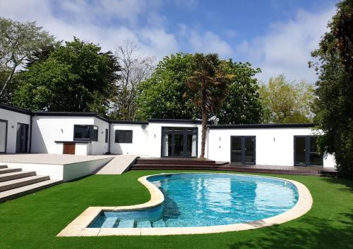 a house with a swimming pool in the yard at Tranquil & Unique Villa on the UK's sunniest place in Ratton Village