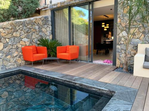 un patio avec des chaises oranges et une piscine dans l'établissement Le paradis sur mer 2, à Six-Fours-les-Plages