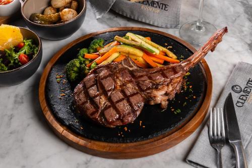 a steak and vegetables on a plate on a table at Hotel GRALTA in Jalostotitlán