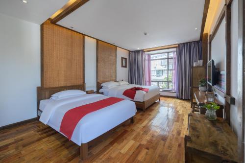 a hotel room with two beds and a television at 云海酒店 in Zhangjiajie