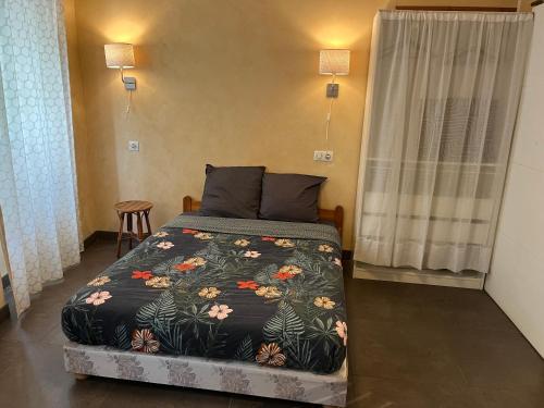 une chambre avec un lit avec un couvre-lit fleuri dans l'établissement Studio 25m2 tout équipé Eauze, à Eauze