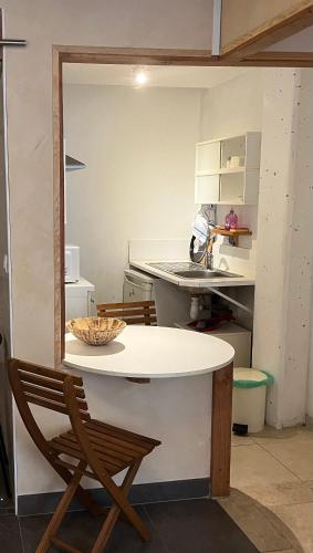 une table et une chaise dans la cuisine dans l'établissement Studio 25m2 tout équipé Eauze, à Eauze