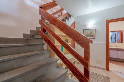 a staircase in a house with wooden railings at Le colline sul mare in Sortino