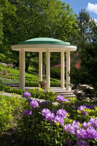 a gazebo in a garden with purple flowers at Labela Luhačovice Apartment in Luhačovice