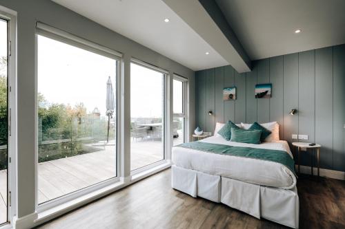 a bedroom with a bed and a large window at Cliff Cottage - Luxurious Seaview Retreat in Gorleston-on-Sea