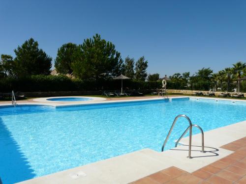 a large swimming pool with blue water at Arcos Gardens Sol Rent Golf in Arcos de la Frontera
