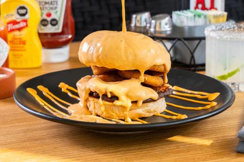 a sandwich on a black plate with caramel sauce at Hotel GRALTA in Jalostotitlán