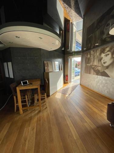 a living room with a table and a painting on the wall at Auszeit am Dankernsee in Altharen
