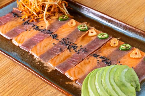 a plate of sushi with fish and cucumbers on it at Hotel GRALTA in Jalostotitlán