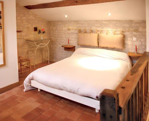 a bedroom with a large white bed in a room at Maison familiale paisible proche de Braslou + jardin spacieux in Braslou