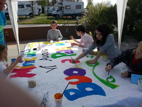 a group of people sitting around a table with a birthday cake at San Francesco Camping Village in Desenzano del Garda