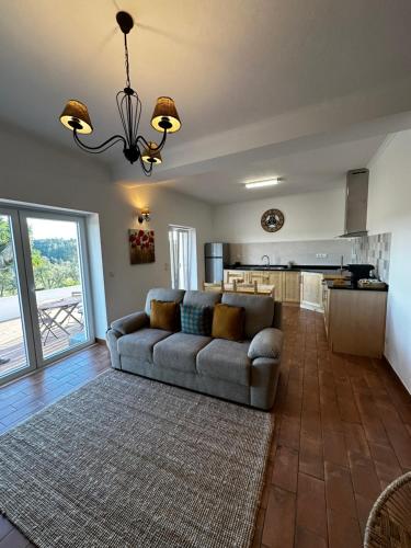 a living room with a couch and a kitchen at Monte da Caniveta - Casa dos Compadres in São Luis