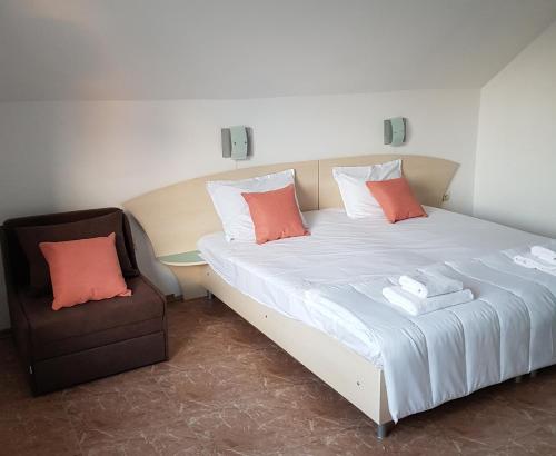 a bed and a chair in a room at Family Hotel Magnolia, Sunny Beach in Sunny Beach