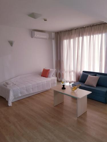 a room with a bed and a couch and a table at Family Hotel Magnolia, Sunny Beach in Sunny Beach