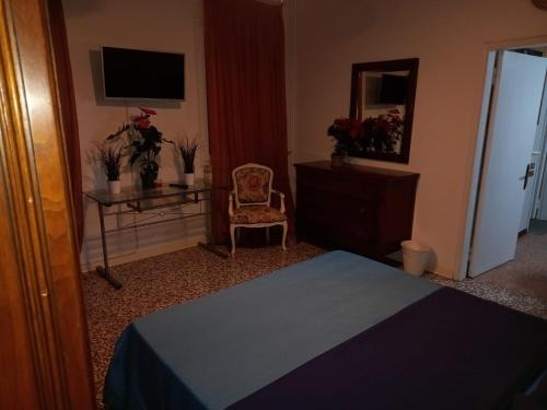 a bedroom with a bed and a chair and a mirror at Dimora ANETT B&B HOUSE in Codevigo
