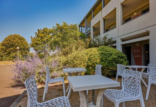 a group of chairs and a white table and chairs at B&B HOTEL AVRANCHES Baie du Mont St-Michel in Le Val-Saint-Père