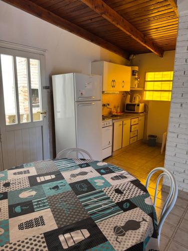拉斯格路塔斯Nita Apart的厨房里有一张桌子和一台白色冰箱