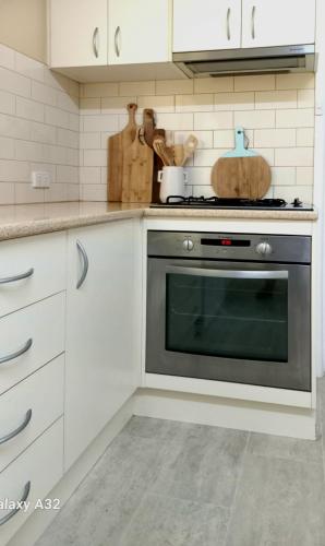 a kitchen with white cabinets and an oven at HUNTER COTTAGE EUROA - "A great weekend escape" in Euroa