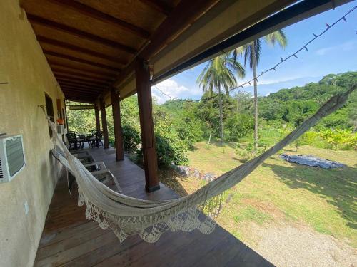 a hammock on the porch of a house at Bonita habitación en acogedora cabaña a tan solo 3 minutos de Sayulita in San Ignacio