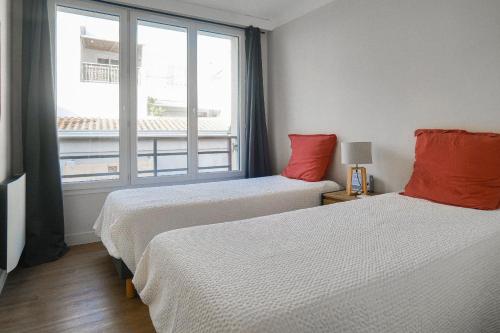 Una habitación de hotel con dos camas y una ventana. en Appartement rénové idéalement situe dans le centre piéton des Sables d'Olonne, en Les Sables-dʼOlonne