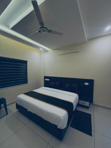 a bedroom with a bed and a ceiling fan at Azay Luxurious Apartment in Kalpetta
