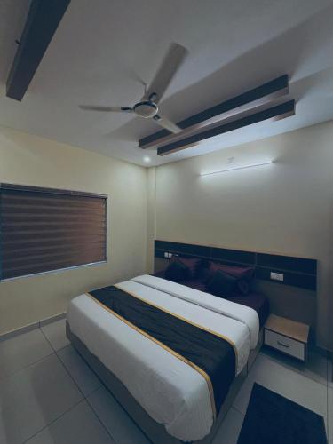 a bedroom with a large bed with a ceiling at Azay Luxurious Apartment in Kalpetta