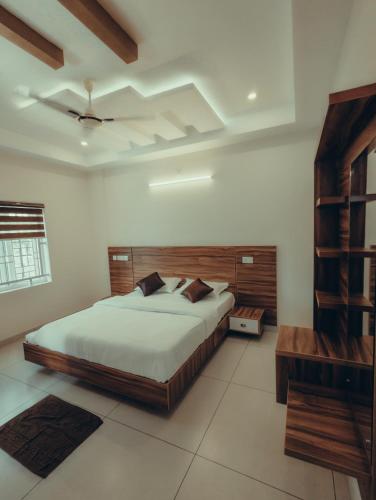 a bedroom with a large bed in a room at Azay Luxurious Apartment in Kalpetta