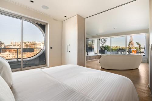 - une chambre avec un grand lit blanc et une grande fenêtre dans l'établissement Splendide Apartment Rooftop Jacuzzi Tour Eiffel AC, à Paris