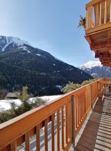 a wooden deck with a view of a mountain at Naturhotel BERGhof in Pfunds