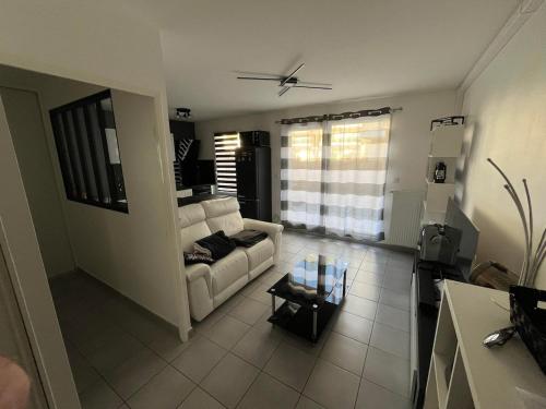 un salon avec un canapé blanc et une table dans l'établissement Since 1996 - Groupama Stadium, LDLC Arena, Eurexpo, Lyon, Appartement Calme, à Décines-Charpieu