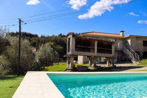 a house with a swimming pool in front of it at Casa da Laranjeira Turismo Rural by Gerês Casas in Vieira do Minho