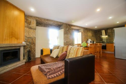 a living room with a couch and a fireplace at Casa da Laranjeira Turismo Rural by Gerês Casas in Vieira do Minho