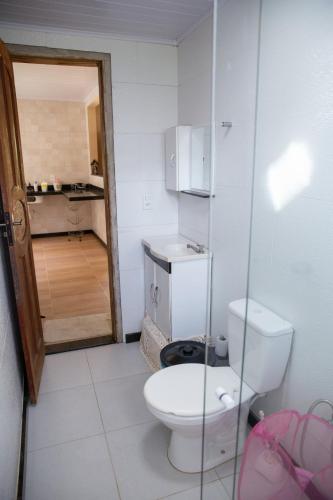 a white bathroom with a toilet and a sink at Sitio encantador e tranquilo com churrasq e Wi-fi in Marechal Floriano