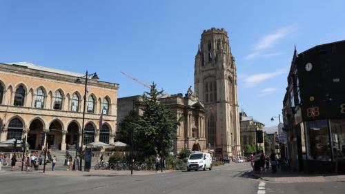 a white van driving down a city street with a clock tower at Georgian Shared House No'3 - By Clifton Short Lets in Bristol