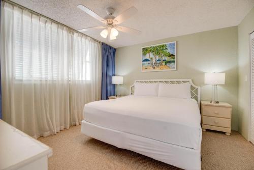 a bedroom with a white bed and a window at The Salt Cay - Sunrise Suites in Key West