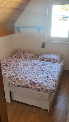 a bed sitting in a room with a window at AlVa- relax a oddych v Slovenskom raji in Dedinky