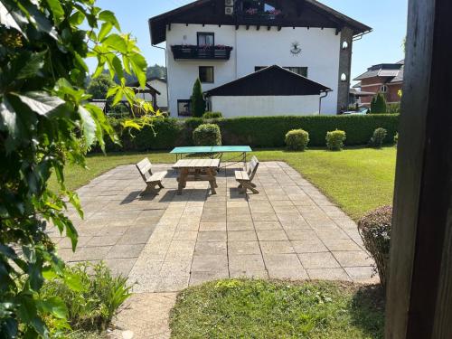 a picnic table and two chairs on a patio at im MITanond schlafen - das Ferienhaus am Keutschachersee in Plaschischen