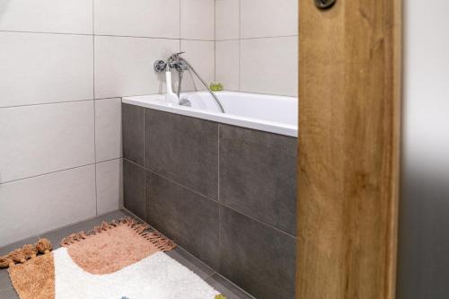a bathroom with a bath tub and a rug at UBYTKO - Apartment in Blahová - Experience Rye Island in Blahová