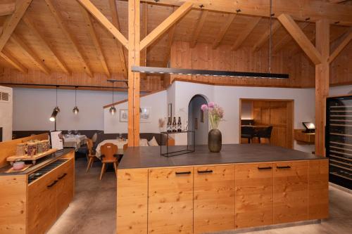 an open kitchen and dining room with wooden ceilings at Naturhotel BERGhof in Pfunds