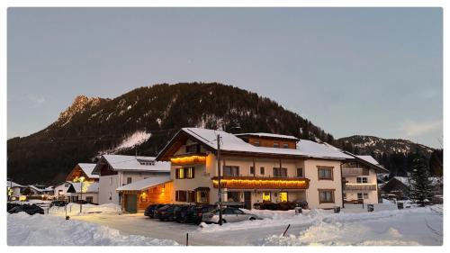 a large building with cars parked in the snow at Haus Luise in Bad Hindelang