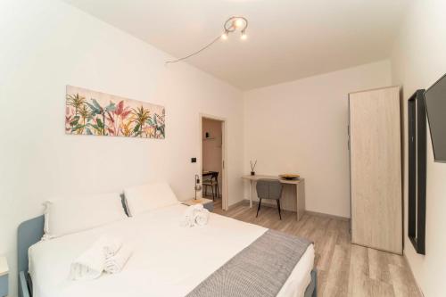a bedroom with a white bed and a desk at Homely Family 1 in Turin