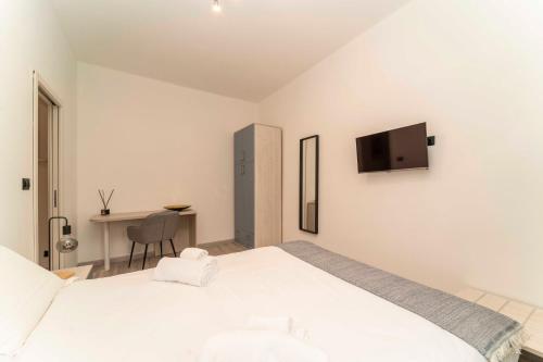 a white bedroom with a bed and a desk at Homely Family 1 in Turin