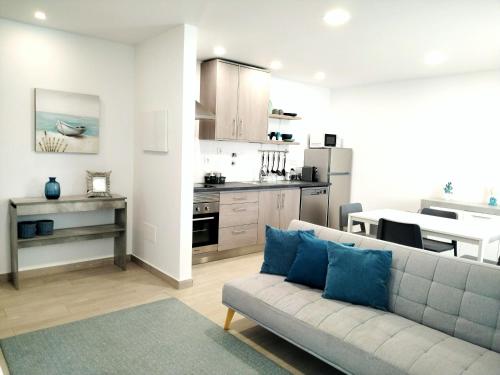 a living room with a couch and a kitchen at Casas de Campo - Real Mar in Ericeira