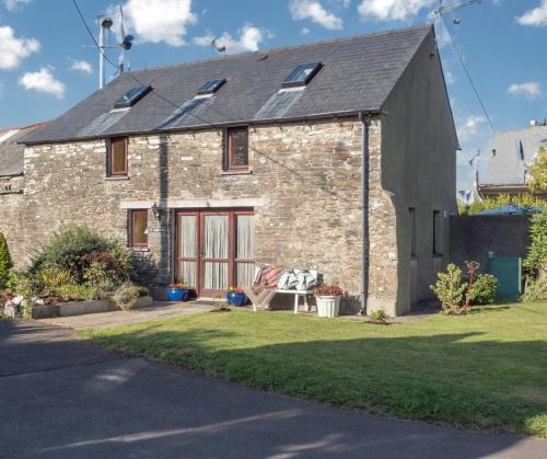 a brick house with a lawn in front of it at Y Cartws Cardigan in Cardigan
